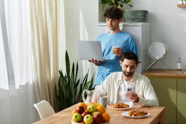 İki adam keyifli bir kahvaltıyı paylaşıyor, evde sevgi ve bağın tadını çıkarıyorlar..