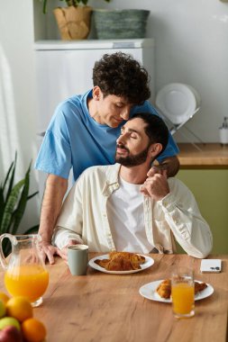 İki adam şık evlerinde kahvaltıda sevgi dolu bir anı paylaşıyor, lgbt kültürünü kucaklıyor..
