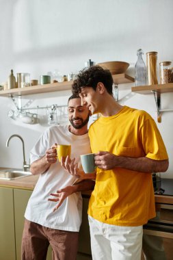 Rahat giysiler içindeki iki adam evlerinde içkilerini yudumlarken birbirlerine eşlik etmekten zevk alırlar..