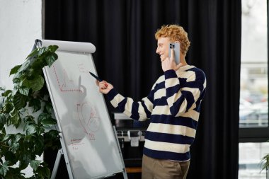 A young man with red hair presents insights on a whiteboard while on a call in a casual office. clipart