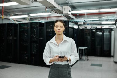 An IT specialist in a white shirt works diligently in a data center with server hardware. clipart