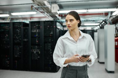 Dedicated IT specialist in a white shirt monitors server status in a high-tech environment. clipart