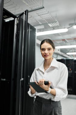 A woman in a white shirt works diligently in a sophisticated server room, overseeing systems. clipart