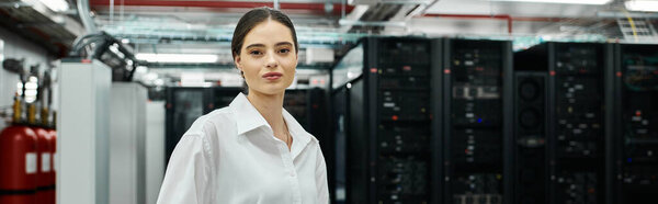 A woman in a white shirt works on server systems in a high-tech data center, banner