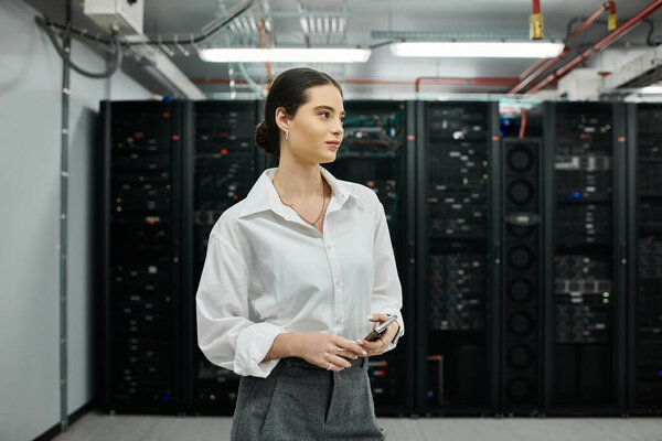 Опытная женщина в белой рубашке сосредоточена на поддержании серверных операций в технологическом центре.