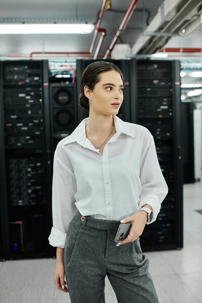 A skilled woman in a white shirt navigates a high-tech server room focusing on digital security.