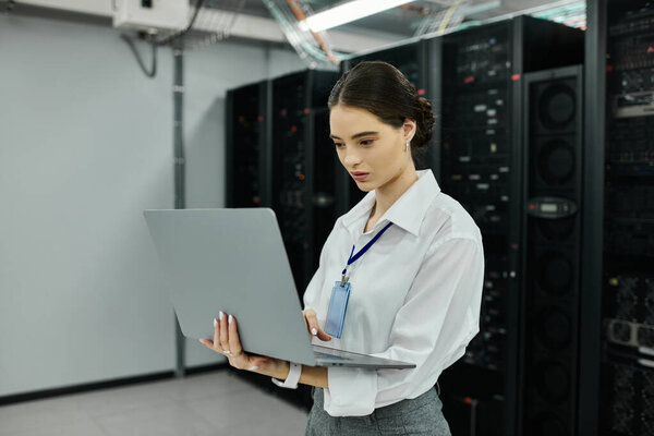 Женщина в белой рубашке управляет компьютерной системой в высокотехнологичной серверной.