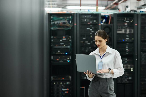 Женщина в белой рубашке сотрудничает с сетевыми системами в современном дата-центре.