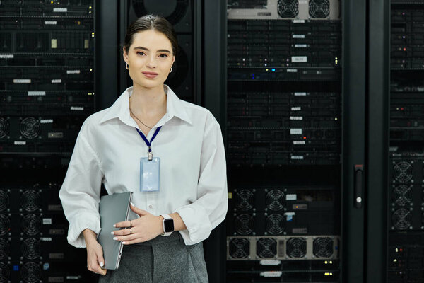 Женщина в белой рубашке усердно работает с серверным оборудованием в технически-ориентированной обстановке.