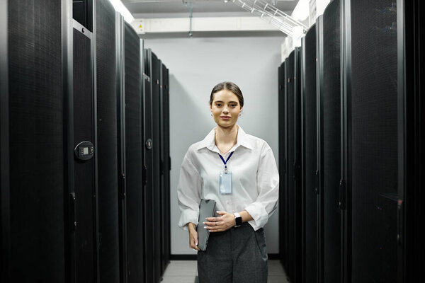 Преданная женщина в белой рубашке усердно работает в высокотехнологичной серверной, поддерживая системы.