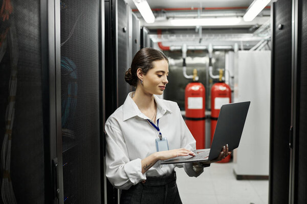 ИТ-специалист усердно работает в гладкой серверной комнате, обеспечивая бесперебойную работу цифровых систем.