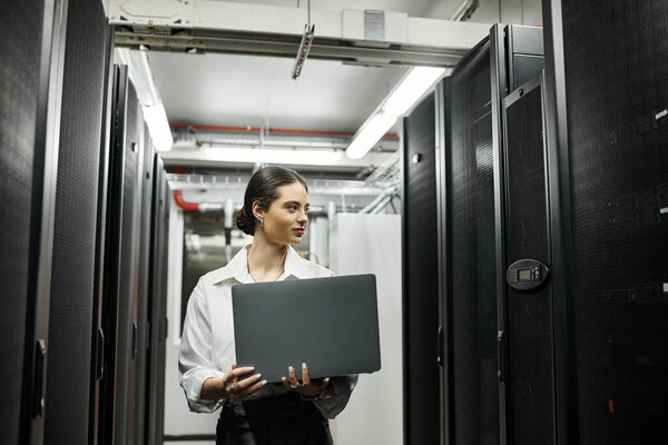 A skilled IT specialist works diligently in a modern server room, managing digital systems.