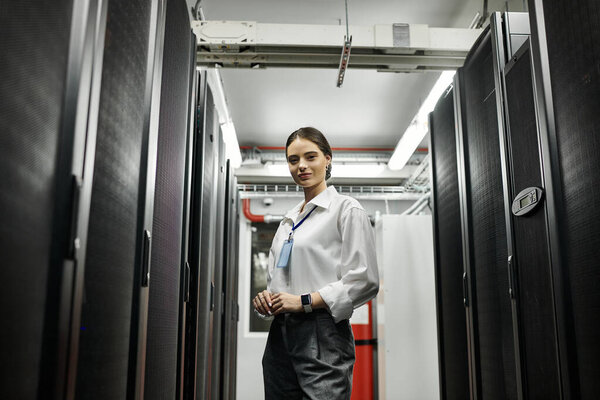 Опытная женщина в белой рубашке усердно работает на передовом серверном оборудовании в центре обработки данных.