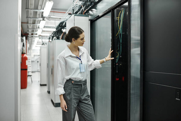 A skilled IT specialist works with computer systems in a contemporary server room.