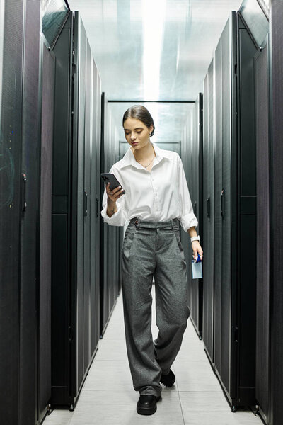 Женщина в белой рубашке ориентируется в серверной, контролирует системы и обеспечивает безопасность.