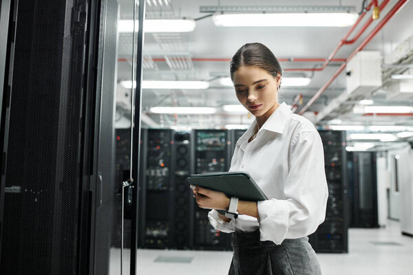 A skilled IT specialist in a white shirt operates hardware within a sleek server room.