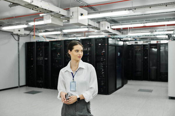 Женщина в белой рубашке контролирует операции в оживленной серверной комнате, обеспечивая цифровую безопасность..