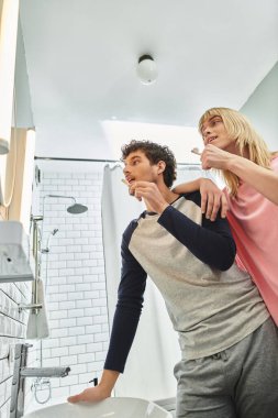 Mutlu çift dişlerini fırçalamayı ve şık bir banyo ortamında gülümsemeyi sever..