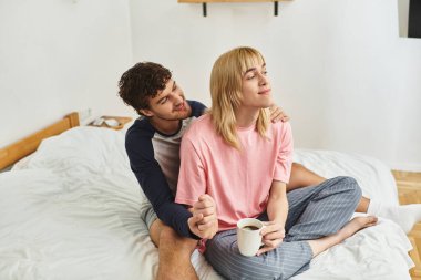 İki erkek sıcak ve davetkar bir yatak odasında kahvelerini içerken şefkatle kucaklaşır..