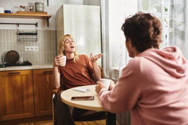 Two men share a heartfelt conversation in a warm kitchen, enjoying each others company. clipart