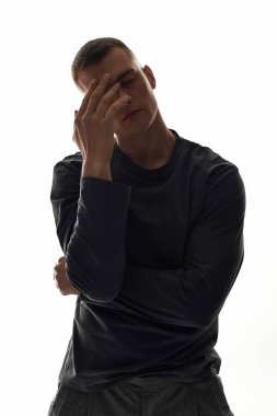 Yakışıklı bir genç adam minimalist bir stüdyoda derin duygular paylaşıyor..