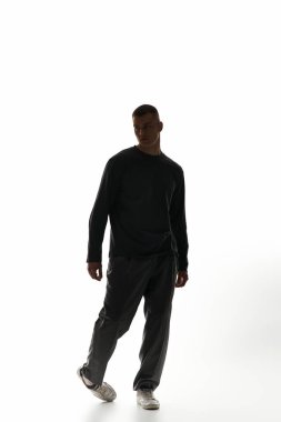 Şık bir genç adam, parlak ve minimalist bir çevrede kendine güvenerek ilerler..