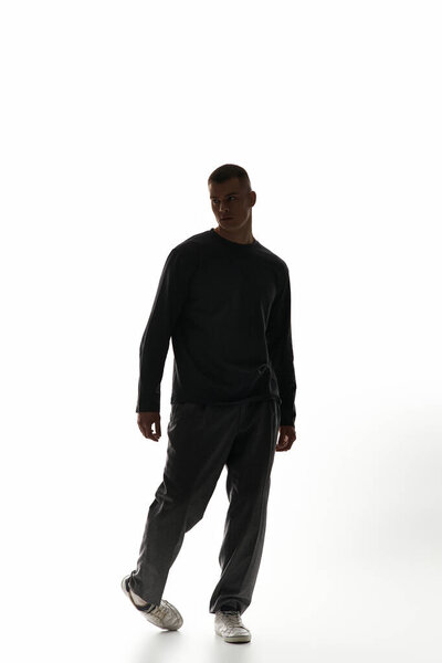 A stylish young man strides forward with confidence in a bright, minimalist environment.