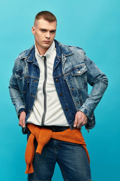 A young man confidently displays a trendy outfit against a vibrant background.