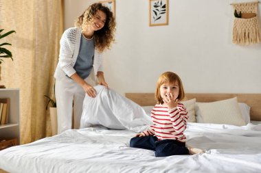 Neşeli bir anne ve kız, yatak odalarını düzenlerken neşeli anlar yaşar..