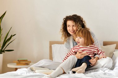 Anne ve kızı bir yatakta dinlenirken kahkahalarını paylaşıyor, güzel anılar yaratıyorlar..