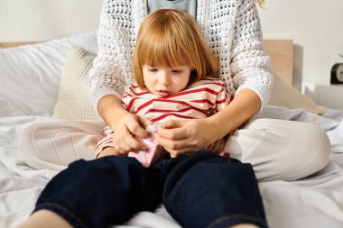 Anne ve kızı, modern ebeveynliği kucaklayan rahat bir yatak odasında yaratıcı bir aktiviteyi paylaşıyor..