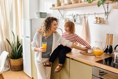 A mother and daughter enjoy a joyful moment in the kitchen together. clipart