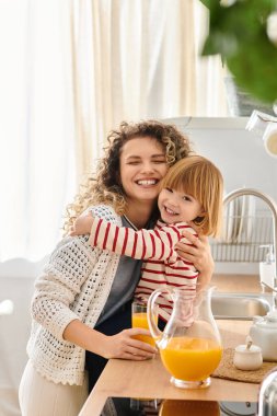 Kıvırcık saçlı anne ve kızı keyifle sıcak mutfaklarında ferahlatıcı içkiler hazırlıyorlar..
