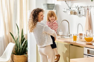 Mother and daughter share laughter and joy while cooking together in their bright kitchen. clipart