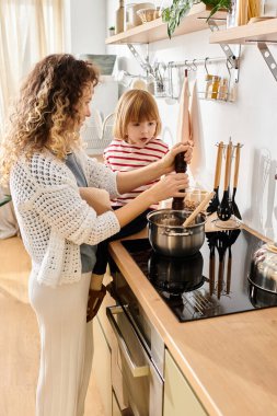 A mother and daughter enjoy cooking together in their modern kitchen, sharing laughter and love. clipart