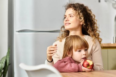 Anne ve kızı, modern ebeveynliğin mutluluğunu kucaklayarak, birlikte güzel bir anı paylaşıyorlar..