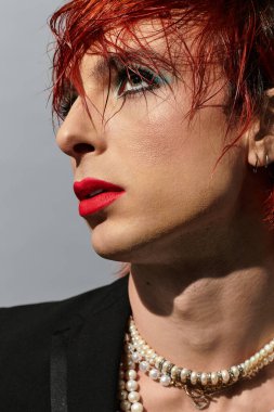 Canlı kızıl saçlı ve kalın makyajlı genç bir adam,... özel yeteneğini sergiliyor..