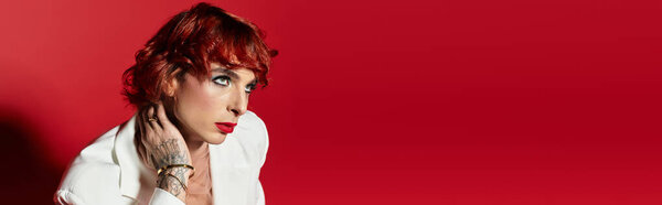 Красивый молодой человек с рыжими волосами занимает захватывающую позу, демонстрируя свой уникальный стиль..