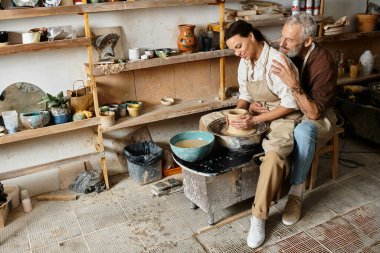 Olgun bir çift çömlek kursunda eğleniyor, kalplerinde sevgi ve kahkahalarla killeri şekillendiriyorlar..