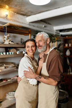 A beautiful mature couple shares quality time at a pottery class clipart