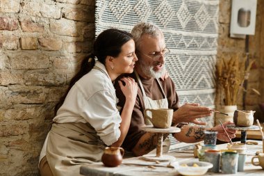 A beautiful couple enjoys quality time as they shape clay in a pottery class, sharing smiles. clipart