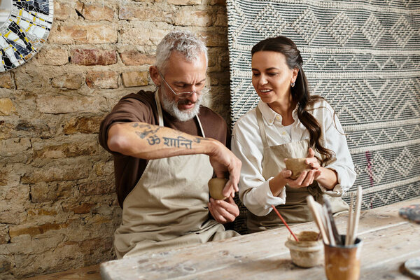 A mature couple enjoys quality time together in a pottery class, shaping clay with joy.