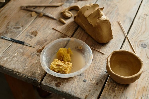 tools, sponges and finished pottery in an inviting studio space.
