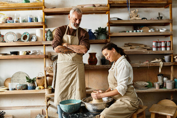 A mature couple enjoys shaping clay together in a pottery class, building connection and joy.