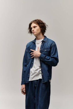 Yakışıklı genç adam kendine güveni tam bir şekilde duruyor, kendine has tarzını sergiliyor..