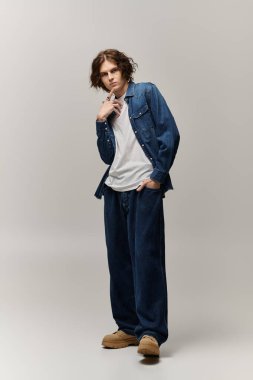 Şık bir genç adam modaya uygun bir kot giysisi, göz alıcı bir cazibe ve kendine güven veriyor..