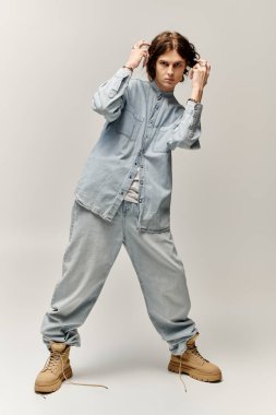 Yakışıklı genç bir adam modaya uygun moda anlayışını, sıradan bir kot pantolonla sergiliyor..