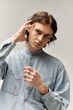 Yakışıklı genç adam modaya uygun kıyafetlerini ve zarif aksesuarlarını sergiliyor..