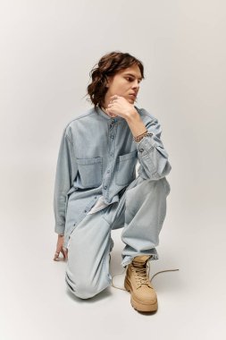 Modaya uygun genç bir adam şık bir kotun içinde özgün tarzını sergileyerek özenle diz çöker..