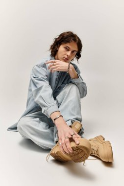 Yakışıklı genç bir adam, rahat bir elbise giyip, kendine güvenle uzanır..